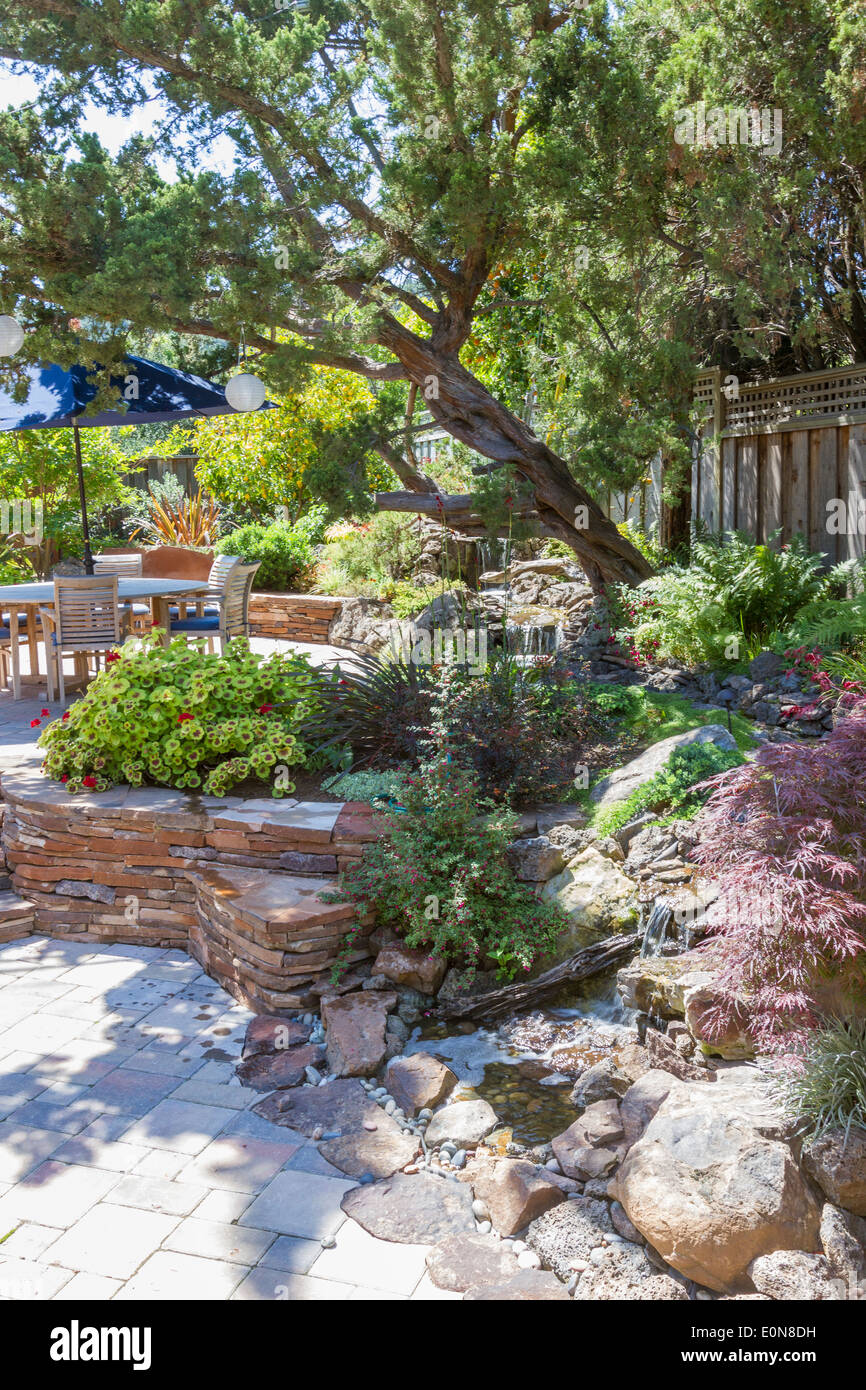 Water Feature Stream Flowing Through Lush Foliage Into Patio In