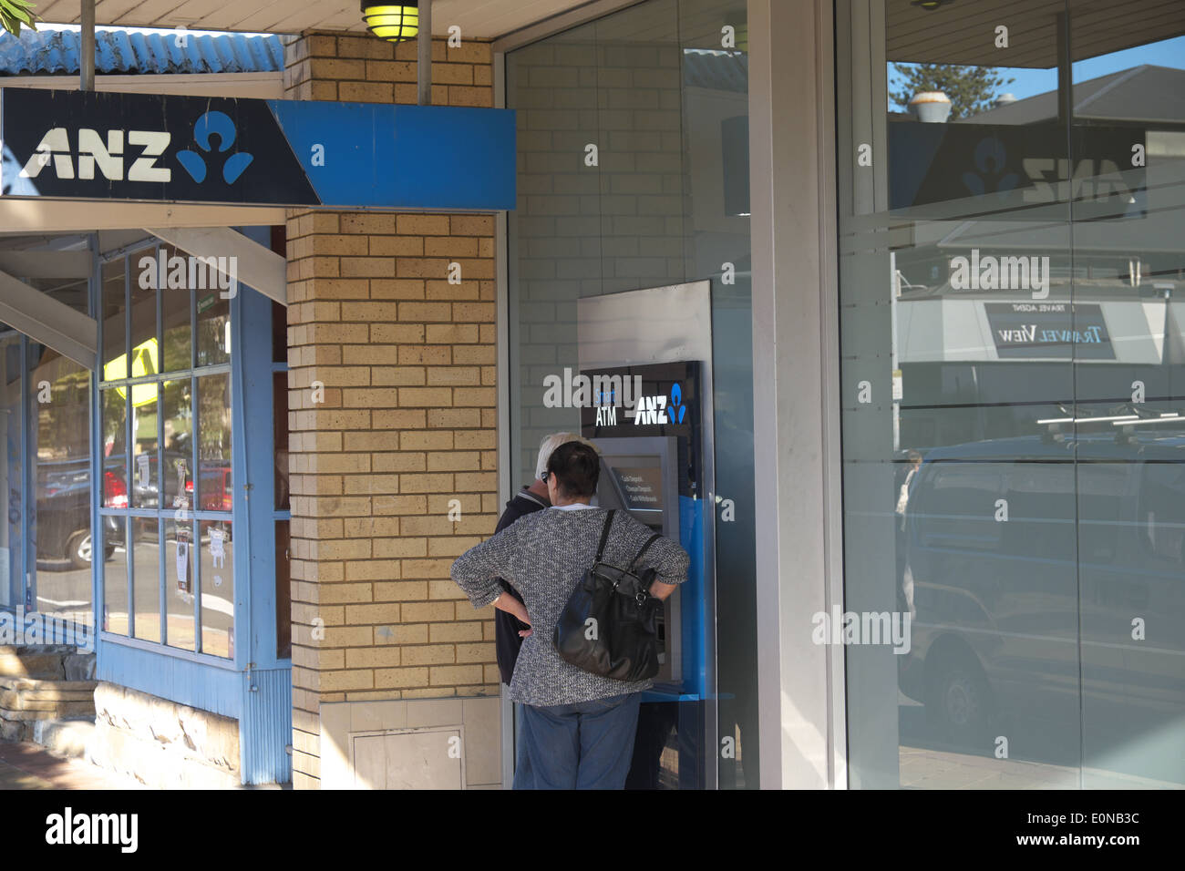 couple withdraw funds from an ANZ bank cash dispenser in avalon,sydney Stock Photo