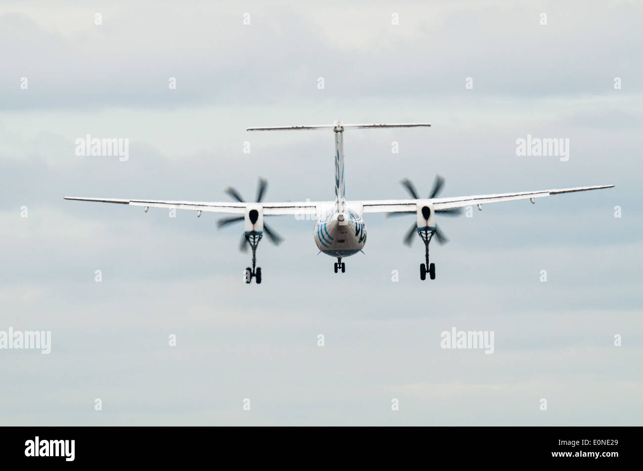 Rear view of a Flybe Dash 8 regional plane with landing gear down on