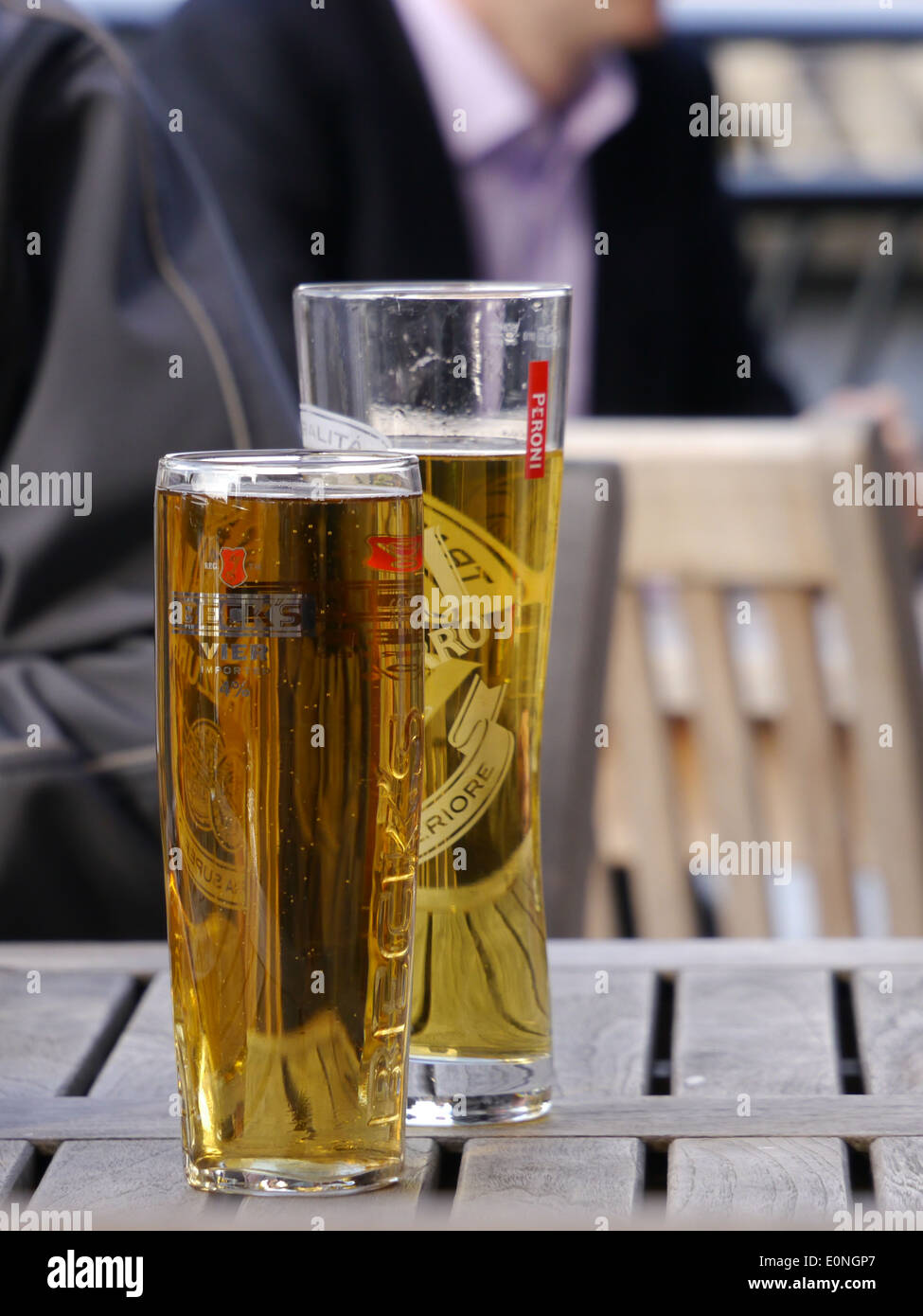 Two tall elegant pint glasses of cold wheat beer with a frothy head on a  wooden bar table conceptual of Oktoberfest Stock Photo - Alamy