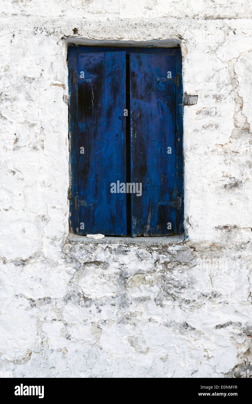Blue shutter in a peeling brick wall Stock Photo