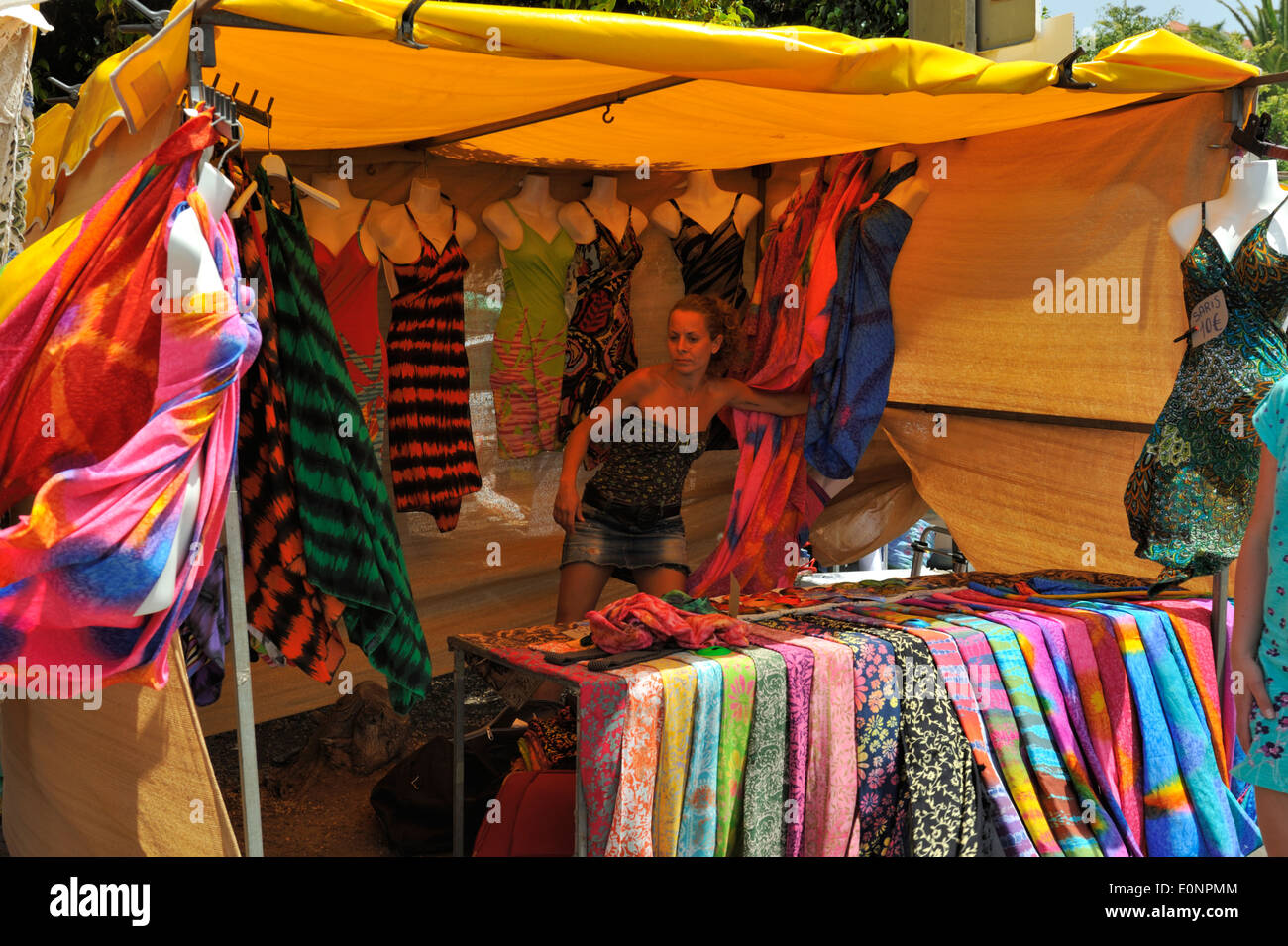 Outdoor market stall selling scarves and dresses Stock Photo