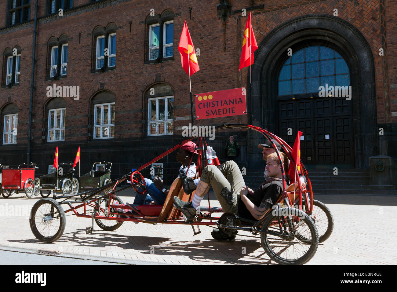 Copenhagen, Denmark. 17th May 2014. Christiania – the free town for alternative life in the middle of Copenhagen – celebrates their very own bikes 30 years anniversary, the special 3 wheeled freight bicycle, with a colorful parade through Copenhagen, staring at the town hall square and  gathering more than 200 bikes. The bikes are designed and produced in Christiania’s own workshop. The “Christiania Bike”, an icon for the free town, is an integrated part of the Copenhagen townscape.  The bike on the photo is an alternative version, called the “Bike Mobil”. Credit:  OJPHOTOS/Alamy Live News Stock Photo