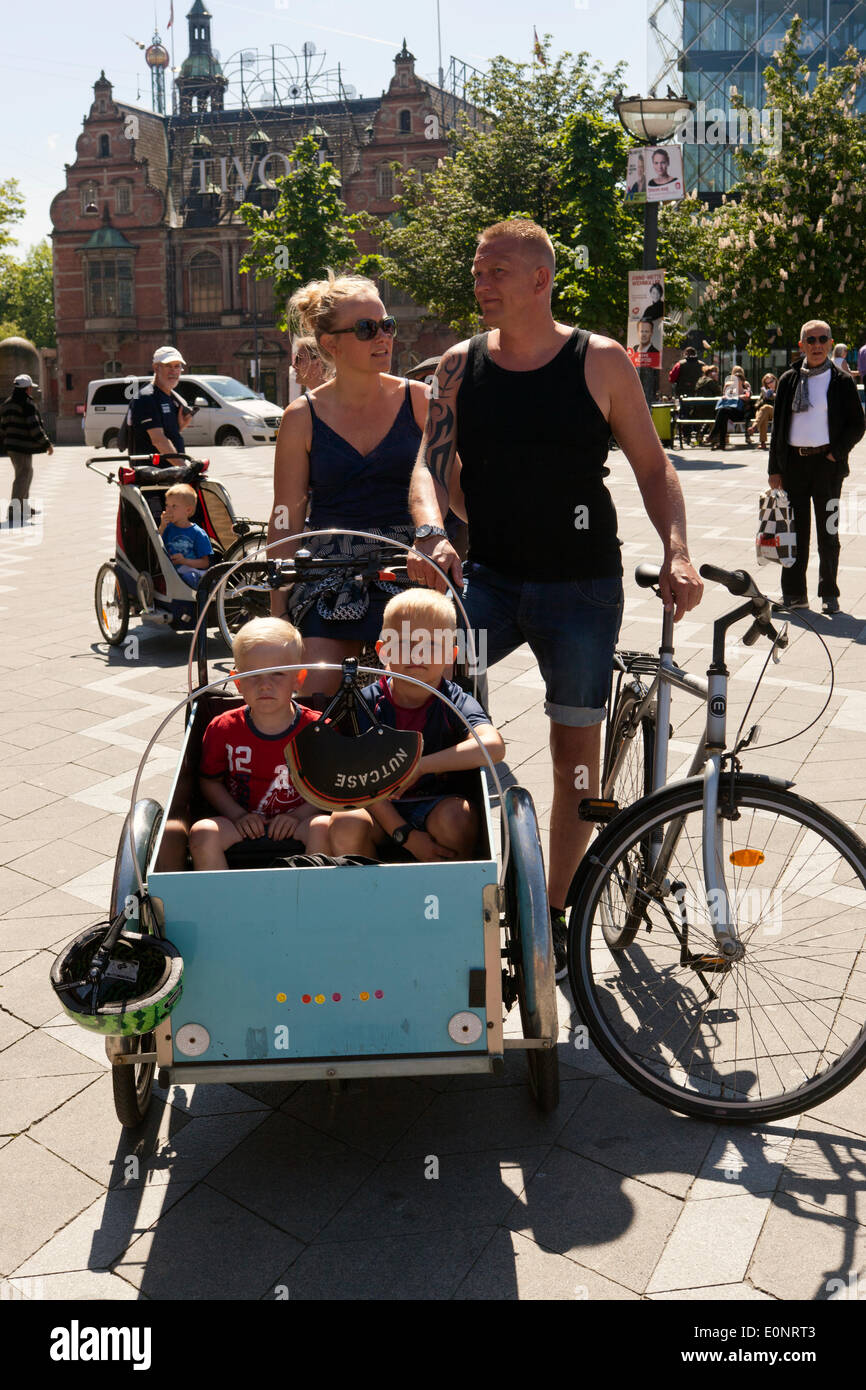 Copenhagen, Denmark. 17th May 2014. parent couple Stine (back, L) and Claus (back R) from Copenhagen with their children, Fredrik 3 years (front, L) and Johnathan 6 years (front, R) at the town hall square where Free Town Christiania celebrates 30 years anniversary for its alternative bike. Claus, an airport security guard, say: “We use the 3 wheeler every day. It is very practical getting the kids in kindergarten, shopping or just getting around, as we don’t have to spent time finding parking space, which is more or less impossible in the inner city”. Credit:  OJPHOTOS/Alamy Live News Stock Photo