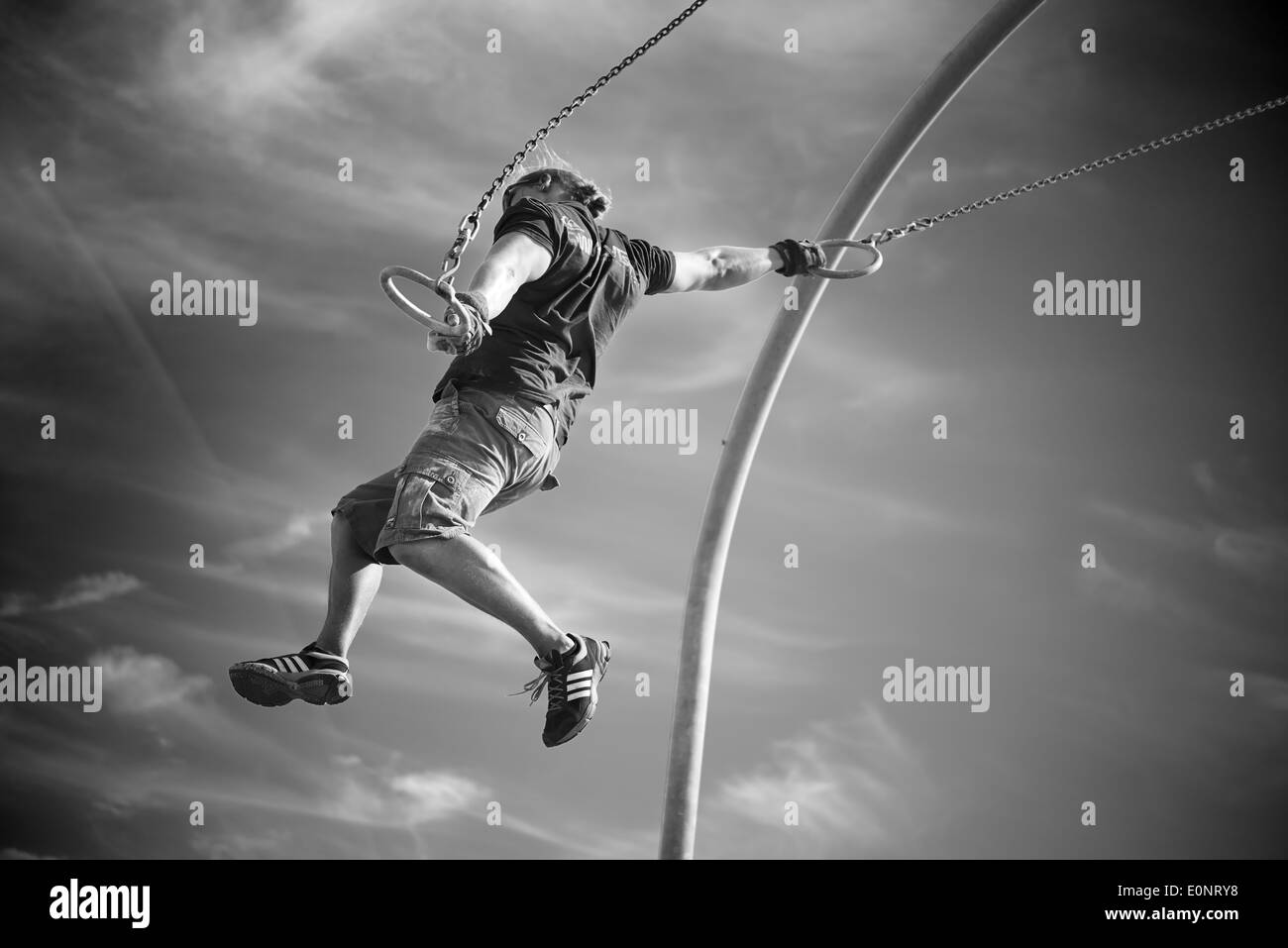 Santa Monica Rings Swinging Sport Athletic Flying Black and White Guy Rings Stock Photo