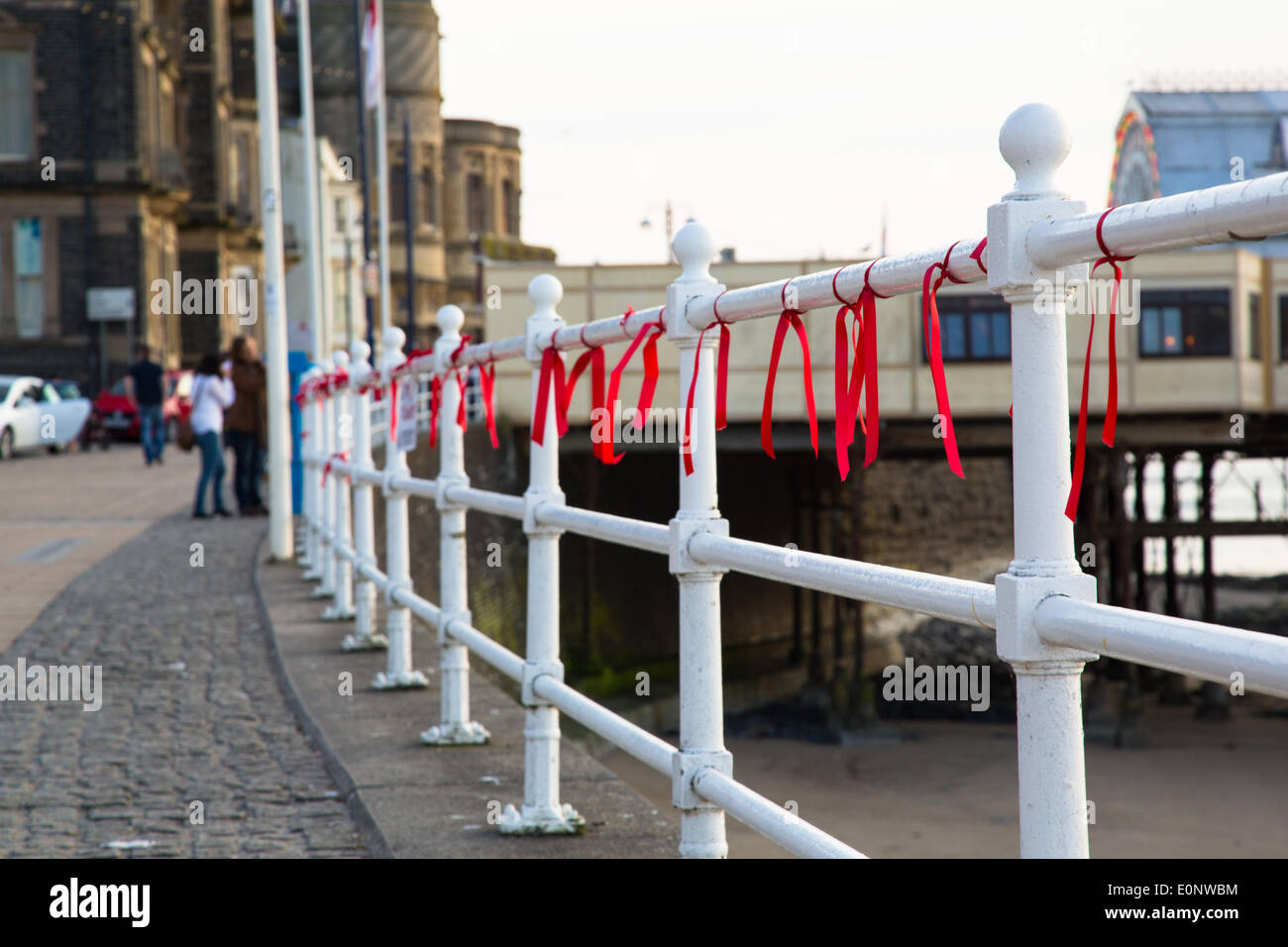 Aberystwyth, Wales, UK. 17th May, 2014.   The railings along the promenade at Aberystwyth, mid Wales, have been adorned with red ribbons to draw attention to the campaign to 'Bring back our girls'. These are the 230 School girls who were kidnapped from the Chibok Government Secondary School by Boko Haram terrorists in Nigeria. Credit:  atgof.co/Alamy Live News Stock Photo