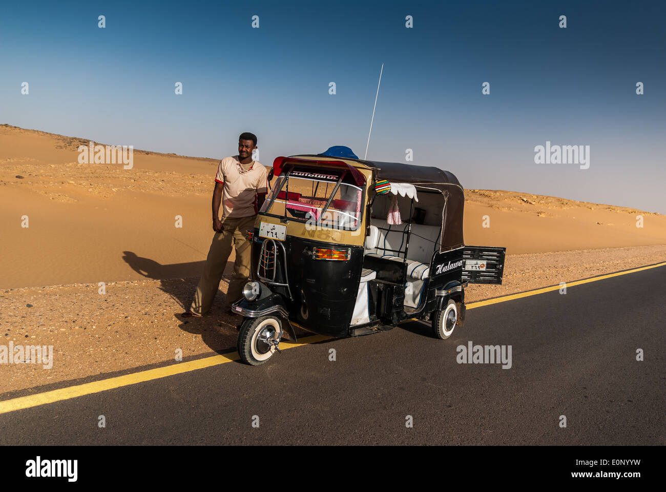 Auto Rickshaw (tuk-tuk, taxi) and its driver, Bayuda Desert near Karima, northern Sudan Stock Photo