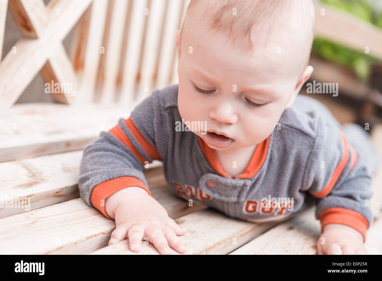 Cute baby boy playing on the bench in a park Stock Photo - Alamy