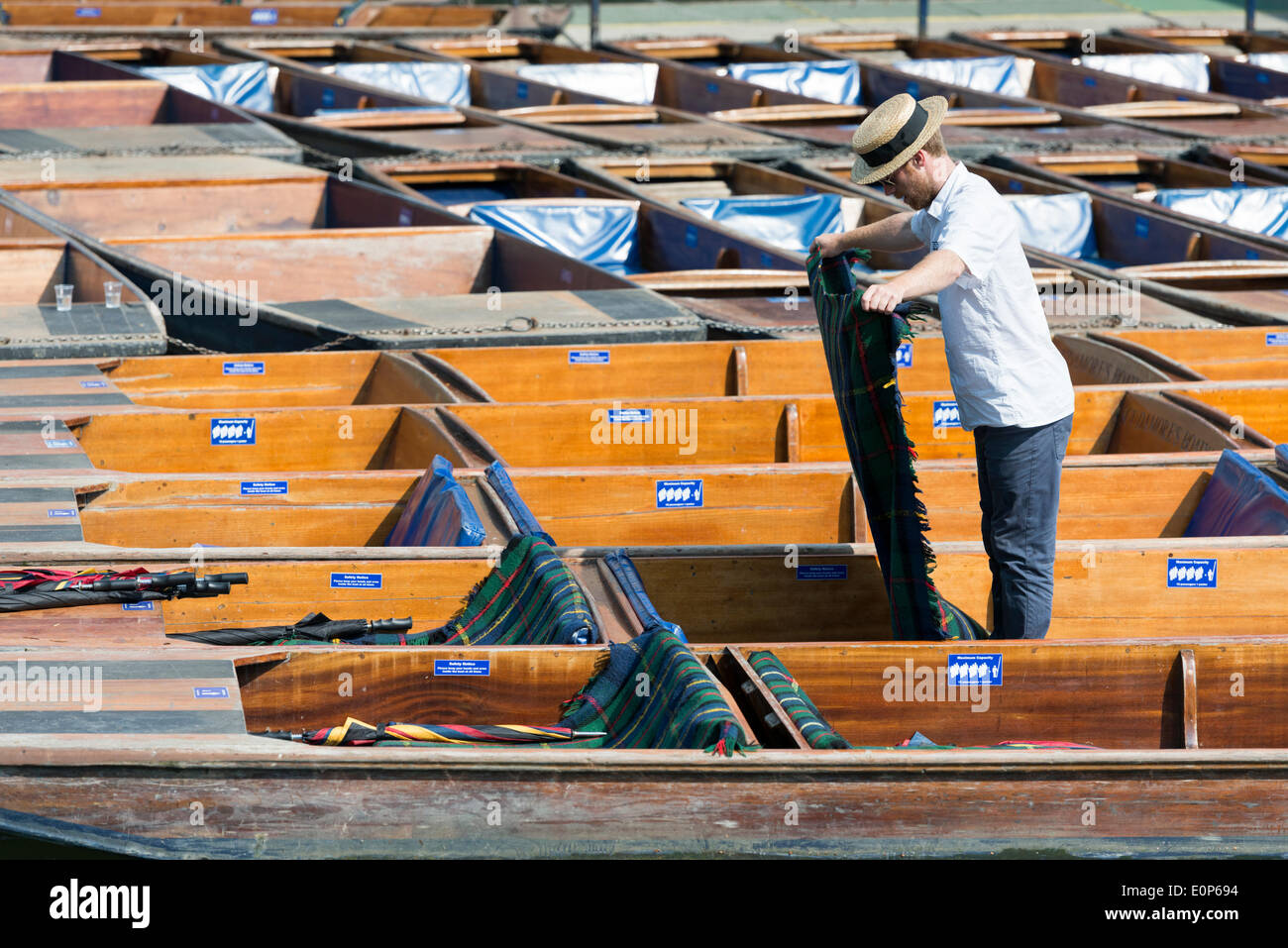 Cambridge UK , 18th May 2014. Staff at Scudamore's Boatyard prepare the punts for a busy Sunday punting on the River Cam, Cambridge UK as another warm sunny day is forecast.  The temperature is expected to reach 24 degrees centigrade.  Many tourists will take chauffeured punt trips along the river enjoying the sights of the historic University buildings.  Credit Julian Eales/Alamy Live News Stock Photo