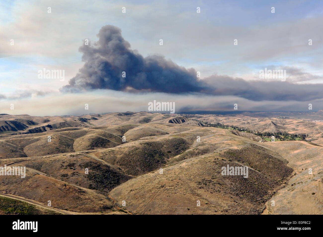 Smoke rises over the drought stricken foothills as the Tomahawk wildfire continues to burn May 16, 2014 around Camp Pendleton, California.  Evacuations forced more than 13,000 people from their homes as the fire burned across San Diego County. Stock Photo