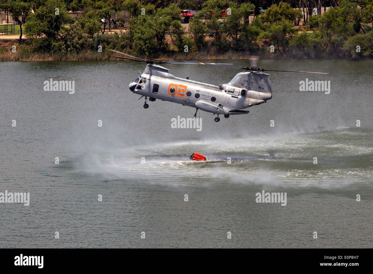 US Marine Corps CH-46 Sea Knight helicopters fills a bambi buckets to fight the Tomahawk wildfire as it continues to burn May 16, 2014 around Camp Pendleton, California.  Evacuations forced more than 13,000 people from their homes as the fire burned across San Diego County. Stock Photo