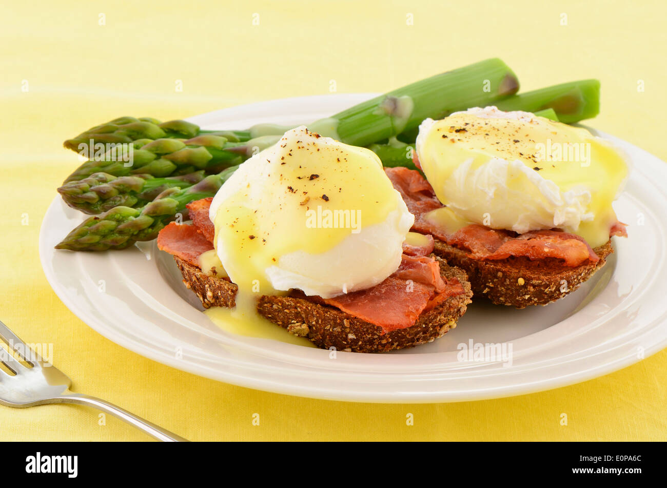 Eggs Benedict with hollandaise sauce on hearty multigrain toast with