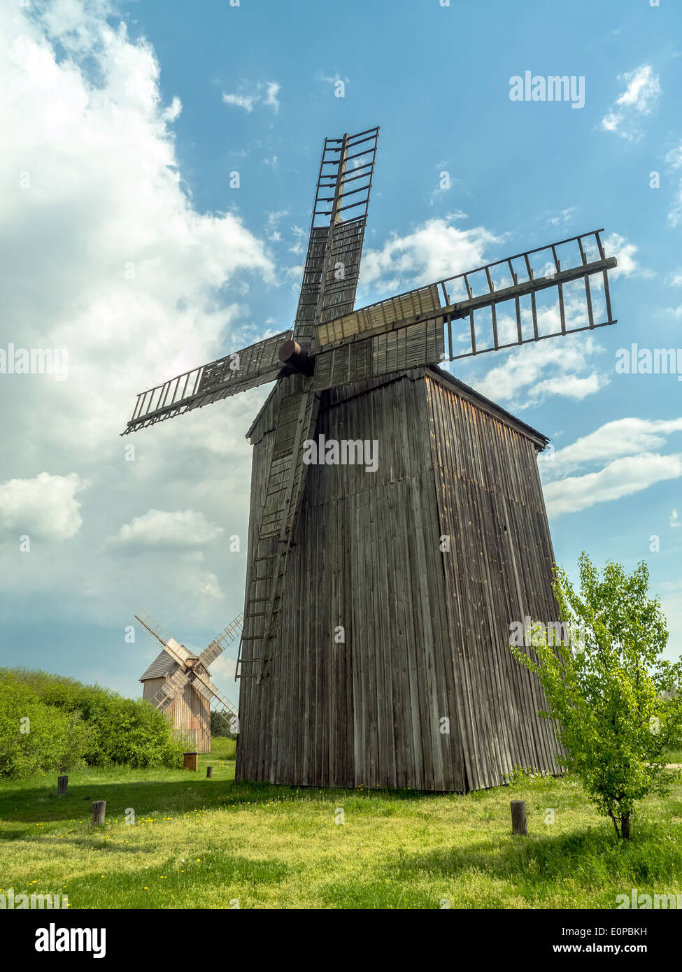 Two old wooden windmills against blue sky Stock Photo