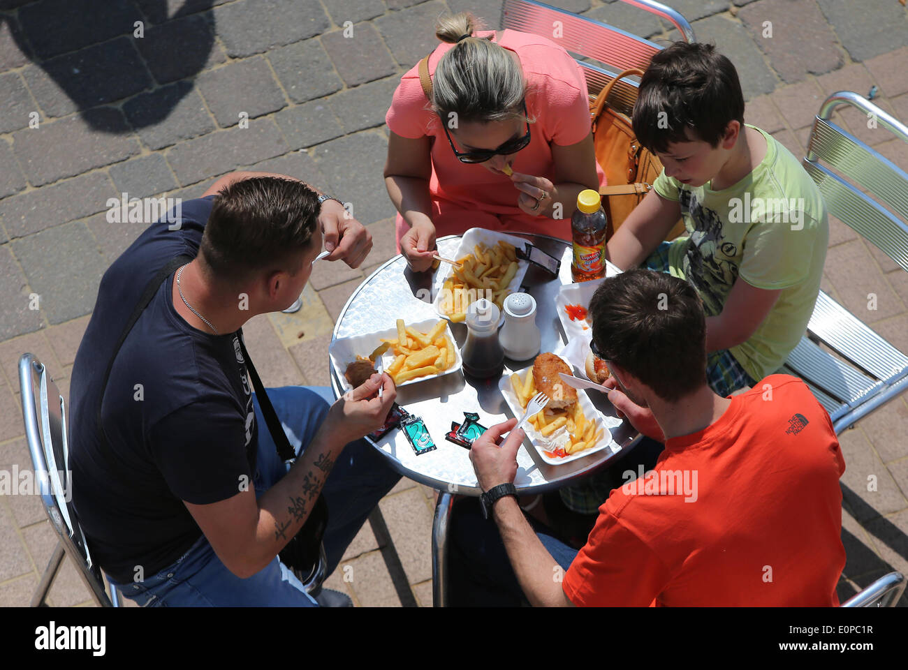 A family eating Fish And Chips on the seafront in Brighton Stock Photo