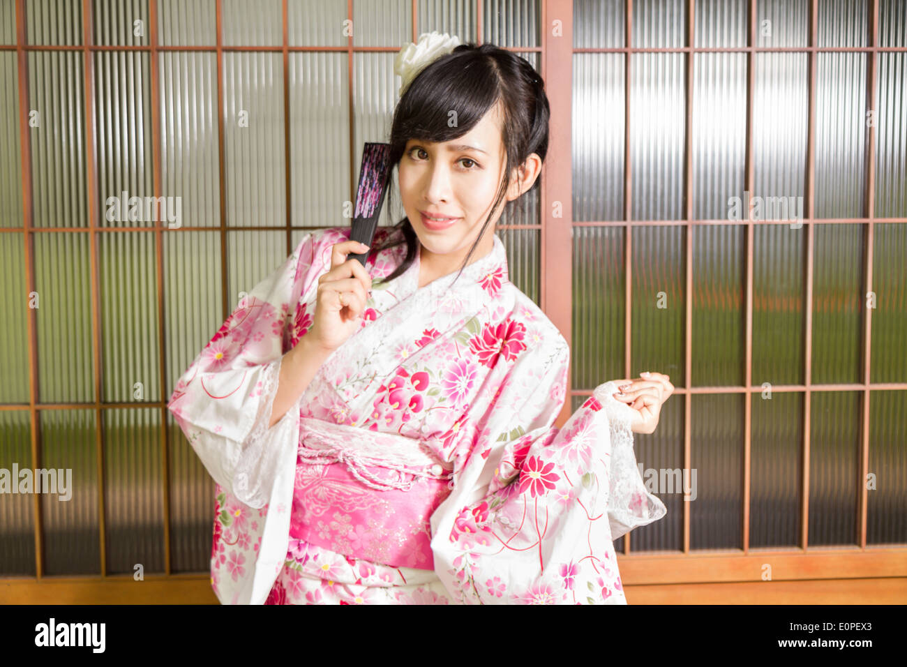 Asian woman in kimono standing by wooden framed windows Stock Photo - Alamy