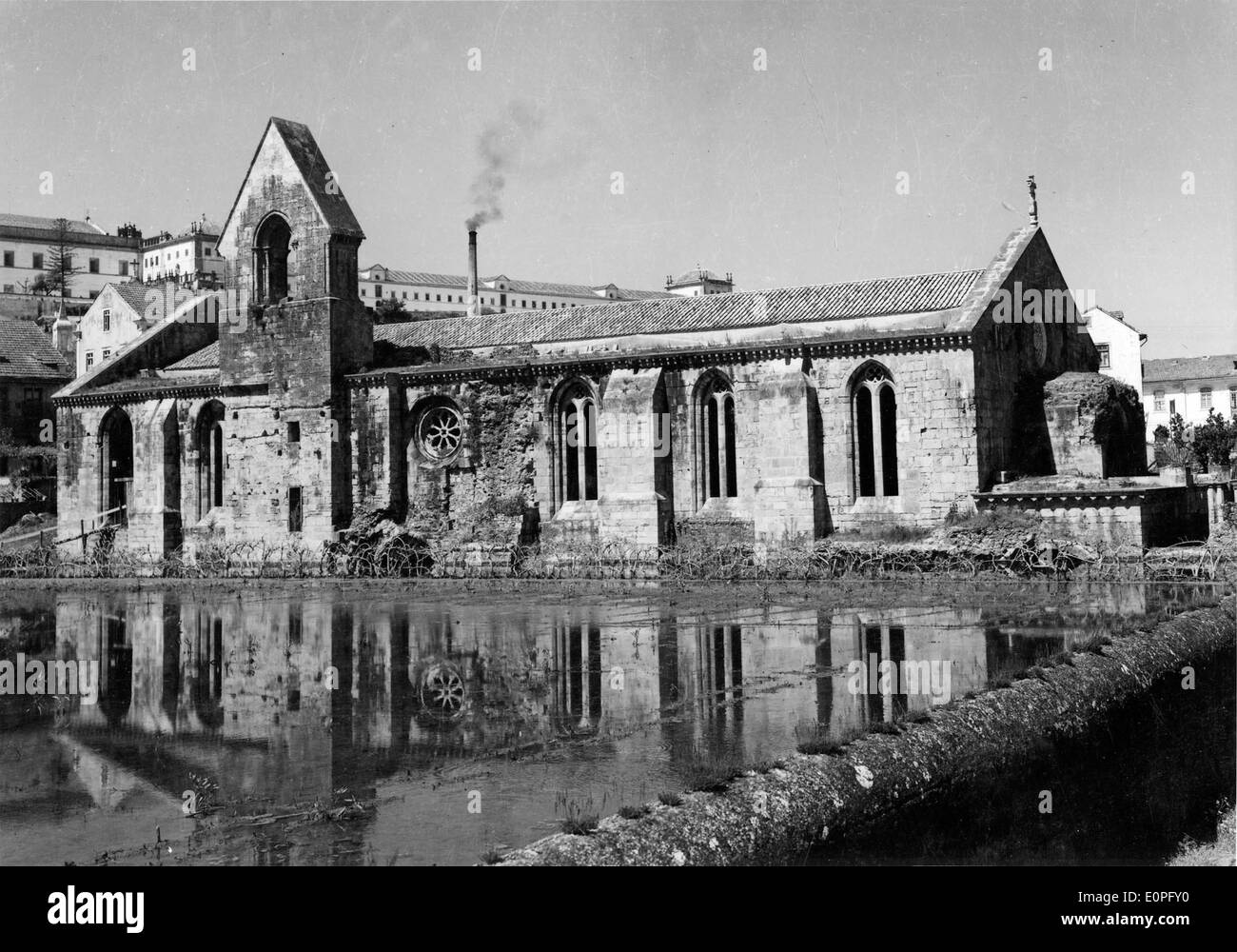 The Mosteiro de Santa Clara-a-Velha, located in Coimbra, Portugal, is a historical Gothic monastery. Once an important religious site, it is now a cultural and architectural landmark, with its well-preserved exterior and reflections in the surrounding water offering a unique view of the past. Stock Photo
