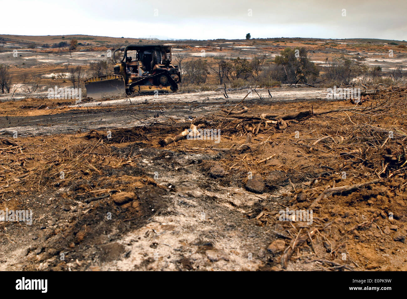 Remains of a firefighting bulldozer after flames from the Tomahawk and Las Pulgas wildfires swept past May 16, 2014 around Camp Pendleton, California.  Evacuations forced more than 13,000 people from their homes as the fire burned across San Diego County. Stock Photo
