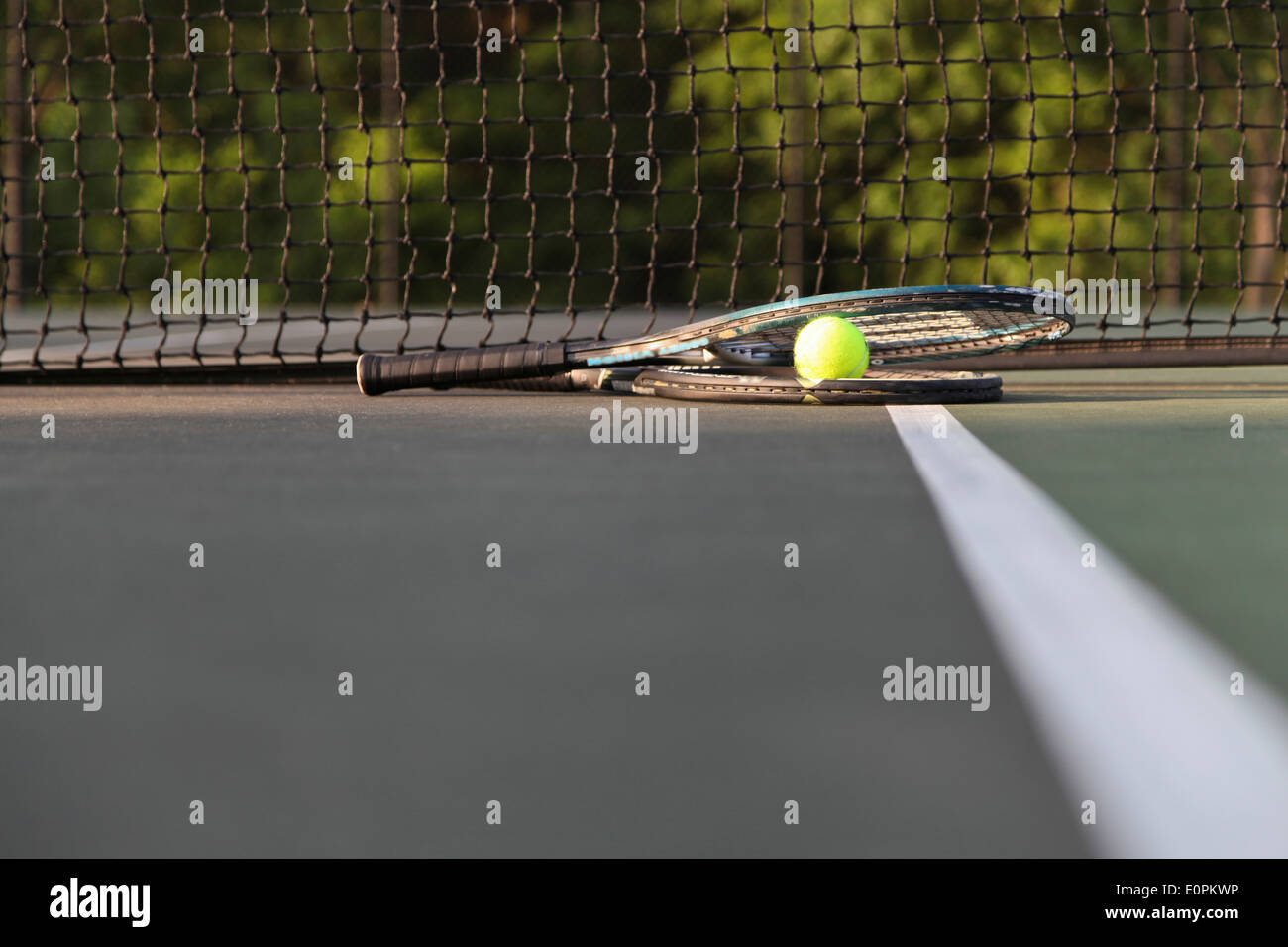 Rackets and ball on court by net. Stock Photo