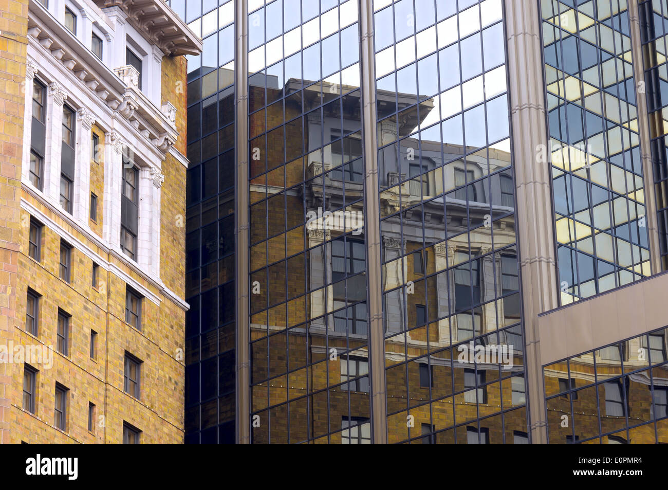 historic building in saint paul reflected in modern glass high rise Stock Photo