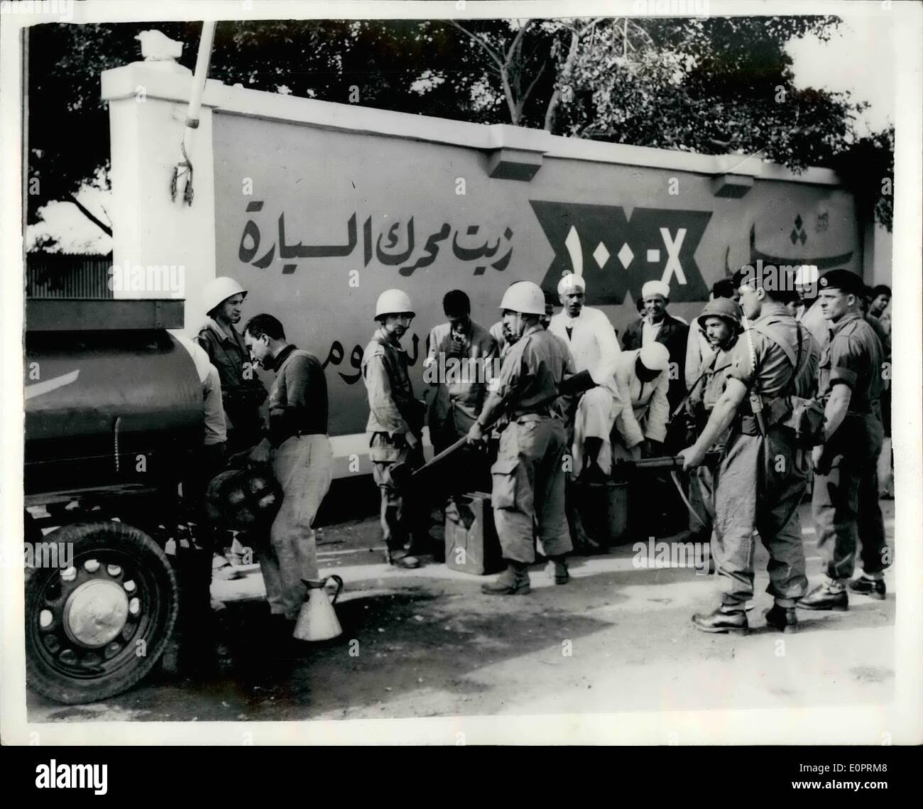 Nov. 11, 1956 - Latest Scenes from the Suez Area... Egyptians Queue for Fuel oil: While motorists in this country are experiencing difficulties in obtaining petrol- owing to the forthcoming petrol rationing - thanks to the Suez situation - the Egyptians are themselves feeling the pinch. They can be seen lining up every day - for kerosene - for cooking purposes. Photo Shows British and French troops supervising a queue of Egyptian at El Raswa on the outskirts of Port Said. The queue is for Kerosene fuel; oil. Stock Photo