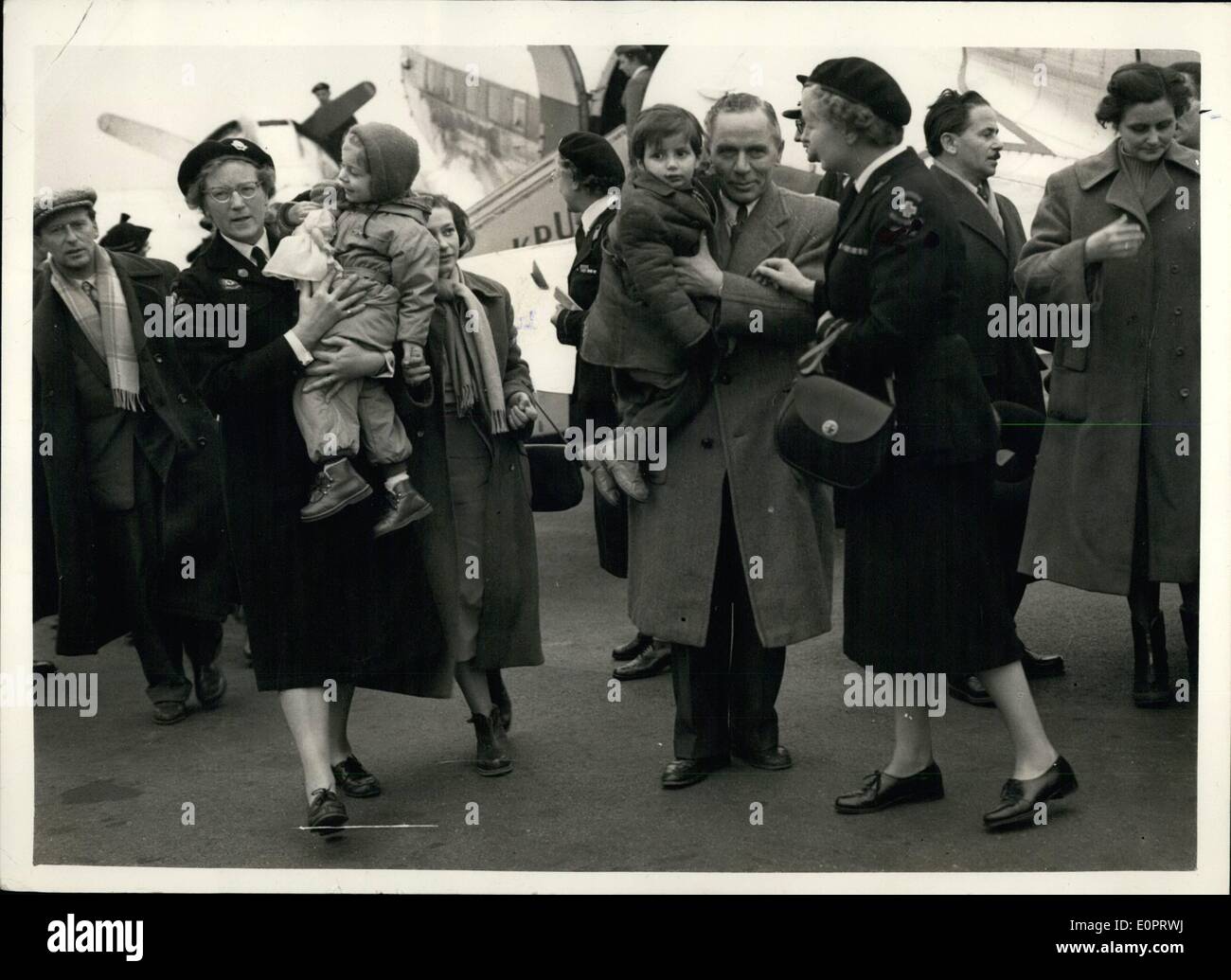 Nov. 11, 1956 - Hungarian refugees arrive in England. escorted by social workers. A party of 61 Hungarian refugees arrived at Blackbushe airport this morning. They are the advance guard of the 2,500 that this country is taking. photo shows Refuges including children are escorted by social workers on arrival at Blackbushe this afternoon. Stock Photo