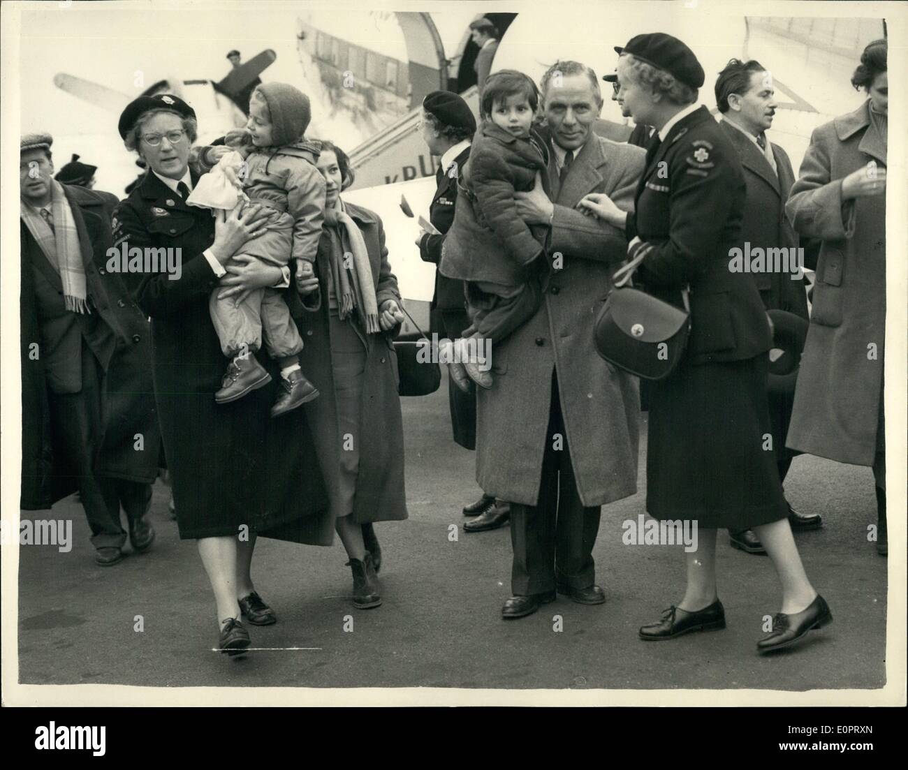 Nov. 11, 1956 - Hungarian Refugeees arrive in England, escorted by Social Workers; A party of 61 Hungarian Refugees arrived at Blackbushe Airport this morning. They are the advance guard of the 2,500 that this country is taking. Photo Shows Refugees including children are escorted by Social workers on arrival at Blackbushe this afternoon. Stock Photo