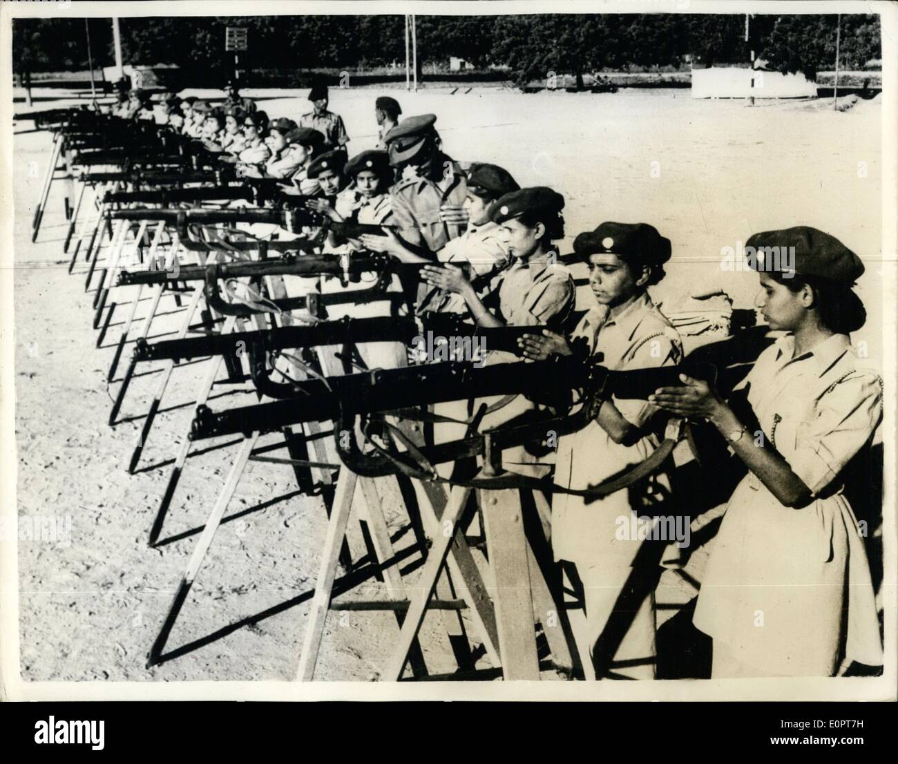 Dec. 12, 1956 - Lady Officer Cadets of The Indian Forces At Rifles Practice....: Lady Officer Cadets of the Junior Wing of the Girls' Division of the National Cadet Corps of the Indian Forces are givemn instruction at Delhi Cantonment. This wing is being rauised under N.C.C.'s expanisojnm programme and the officeres un this picture have just completed their pre-commission training after a two months course in Camp. recruited from various schools, they return to takle charge Junior Wing Units in their representative institution. Stock Photo