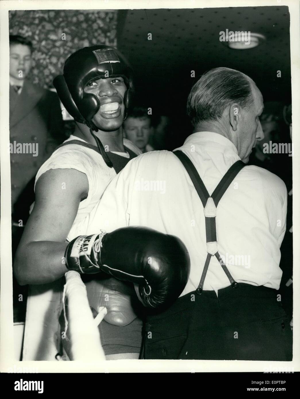 Feb. 02, 1957 - Valdes and Lave sparring but is stopped by trainers after both boxers Refused to stop Boxing: Nino Valdes the Cuban heavyweight who is to fight Joe Erskine at Harringay on 19th. Feb. had a training session at Toby's Gymnasium this afternoon with Kitione Lave the Tonga ''Tiger''. After the bell had signalled end of the first round both boxers refused to stop fighting - and had to be parted by the seconds and trainers. Photo shows Dave Edgar - the agent - keeps a tighted hold on Nino Valdes - until Kitione Lave had left the ring - after the incident this afternoon. Stock Photo