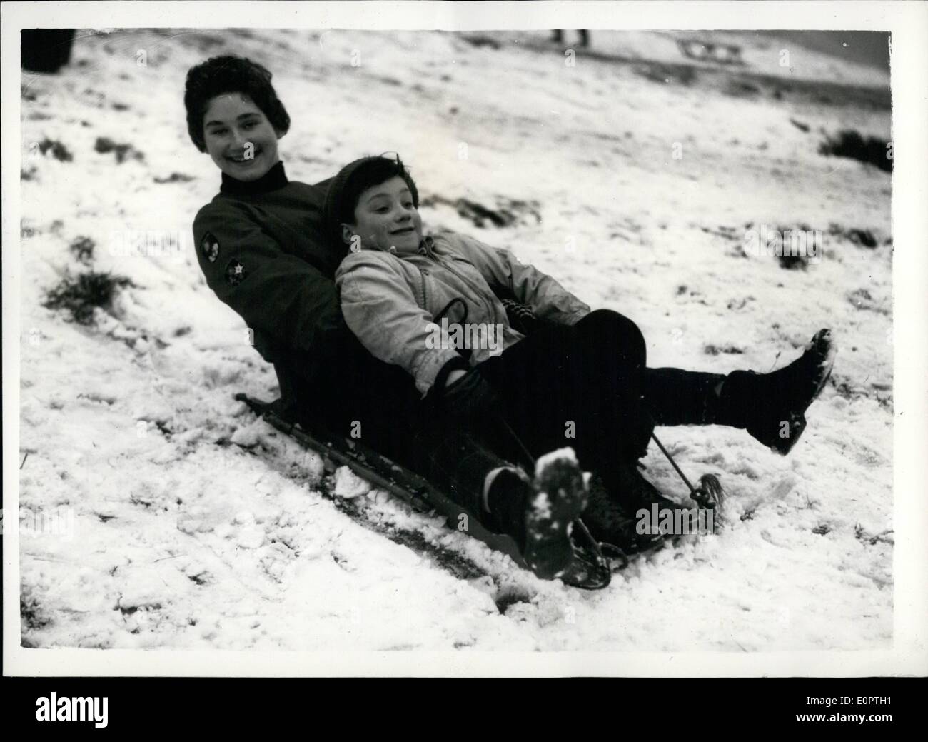 Dec. 12, 1956 - Snow Comes To London And Brings Out The Winter Sports Enthusiasts At Hampstead. Photo shows 8-year-old Richard and 17-year-old Nina Holland, of Handon, are in high spirits on their toboggan at Hampstead Heath today. Stock Photo