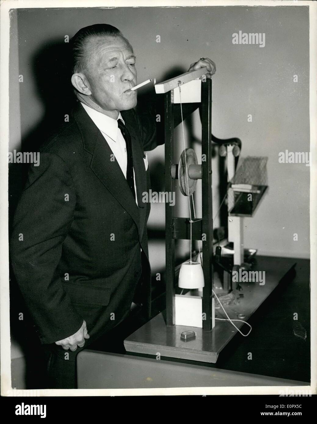Apr. 04, 1957 - The Admiral Strikes A Light With The ''Yonghy-Bonghy-Bo'' Machine: Rear Admiral Tully Shelley demonstrated his ''Yonghy-Bonghy-Bo'' machine as an April Fools Day gag at a board meeting in Regent Street Yesterday. The Admiral - Managing Director of the Company of oil refinery and industrial construction engineers lit a cigarette from this wierd ''Heath Robinson'' contraption Stock Photo