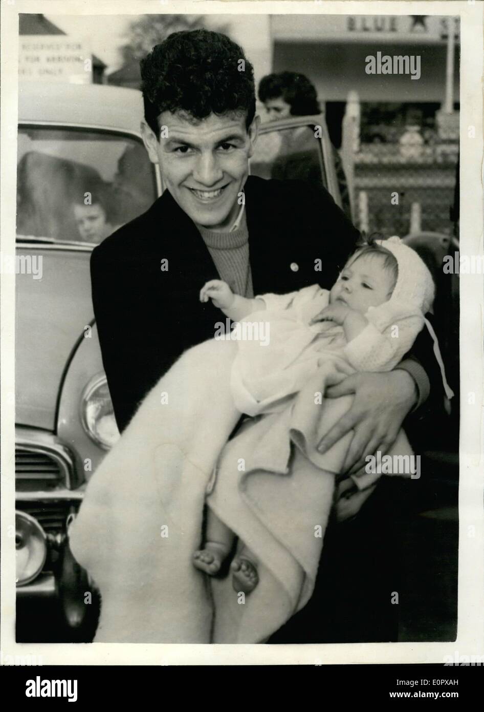 Apr. 04, 1957 - Dai Dower arrives back in London from Buenos Aires. He is met at London airport by his wife and daughter: Dai Dower returned to London by air today from Buenos Aires, where he was recently beaten in his world title fight by Pascual Perez in the first round fly weight championship. He was met at the airport by his wife and baby daughter. Photo shows Dai Dower proudly holds his baby daughter Sandra on his arrival at London Airport today. Stock Photo