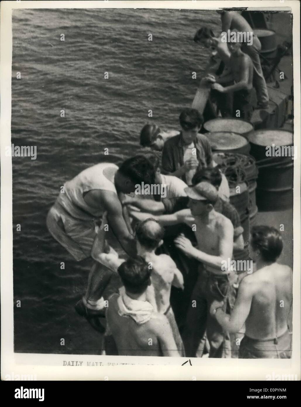 Jul. 07, 1957 - Cargo Steamer Mate Falls Overboard in the Pacific - Treads Water for nine hours waiting for rescue.: In the early hours of a morning last June - in the Pacific - 23 year old Douglas Wardrop second mate of the Cargo steamer British Monarch fell overboard. He was confident that his ship would return for him. He trod water for nine hours and Captain John Coutta retraced the course of his vessel exactly - and picked him up - making one of the most amazing rescues of all time. Photo shows Douglas Wardrop is hauled aboard the British Monarch - after nine hours in the Pacific Ocean. Stock Photo