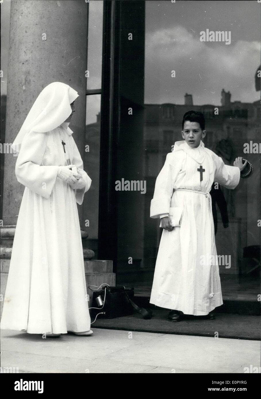 May 05, 1957 - All's not black at Elysee palace: Press photographers who have been on duty at Elysee Palace ever since the crisis started were delighted to see these two 'white apparitions'. The boy and the girl wearing white robes are the children of Captain Schmidt, member of the Presidential Military House. They just came from the Church where they had their first communion. A real boon of cameramen. Stock Photo