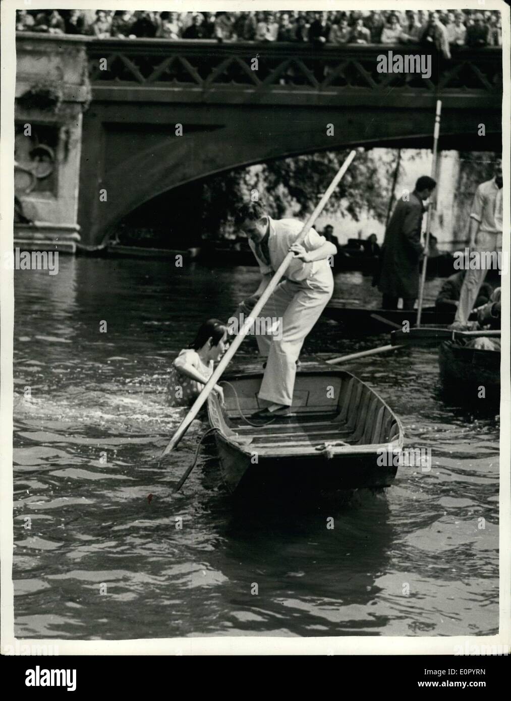 May 05, 1957 - Annual Relay Punt Race... Felicity misses the boat. During the fifth annual relay punt race between the Cambridge University Damper's Club and the Oxford University Club, Felicity Willis, of Newman College, Cambridge, passenger, in the Cambridge punt, and Miss Arline Winter, Oxford's passenger, had to jump into each others punt. Cambridge won for the third year running despite the fact that Felicity once missed the punt altogether and went feet first into the river. Photo shows: Felicity Willis climbs aboard her punt, to make another attempt to jump from one punt to the other. Stock Photo