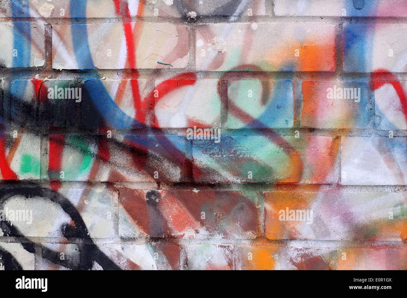Colored graffiti textured background on the brick wall Stock Photo