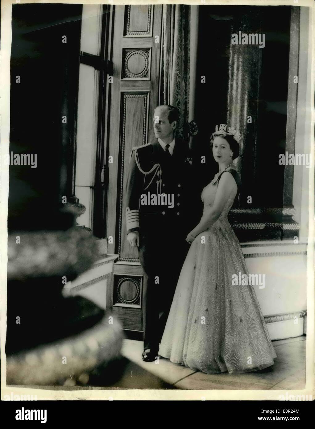 Oct. 10, 1957 - H.M. The Queen and Prince Philip, Duke of Edinburgh.: This picture was taken in the Music Room of Buckingham Palace. Her Majesty is wearing a shimmering gown of white tulle embroidered in silver and gold. The blue ribbon of the most Noble Order of the Garter is over her left shoulder. The Queen's jewels include a diamond and pearl diadem, earrings and necklace, and a diamond bracelet and watch. She wears the Garter Star and the Badge of st. George, set in diamonds; the miniatures on the Queen's left shoulder portray her father and grandfather Stock Photo