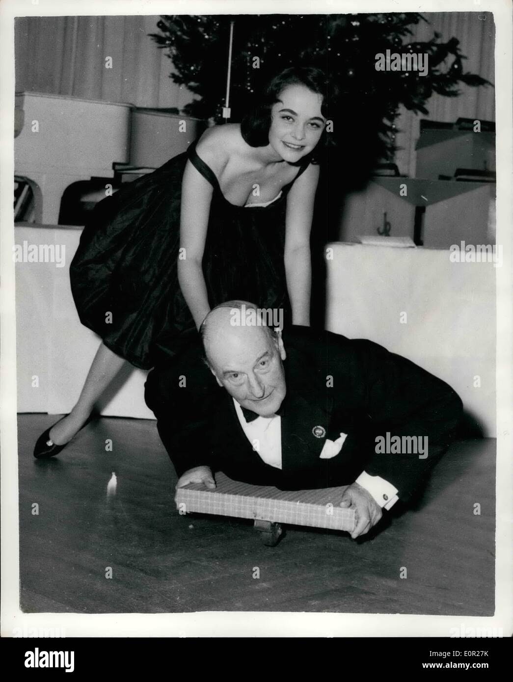 Dec. 12, 1957 - HOW TO BE GAY...AT SEVENTY TWO...LORD BRABAZON GOES TO A PARTY... A big push-and off goes seventy two year old LORD BRABAZON of Tara-on a dummy toboggan-helped by twenty one year old model TANIA EDYE-at the Cresta Ball held at the Savoy Hotel, London...Lord Brabazon is famous for his sporting enthusiast-for his seventieth birthday he celebrated by taking a 90 m.p.h. bob-sleigh ride on the Swiss Cresta Run. Stock Photo