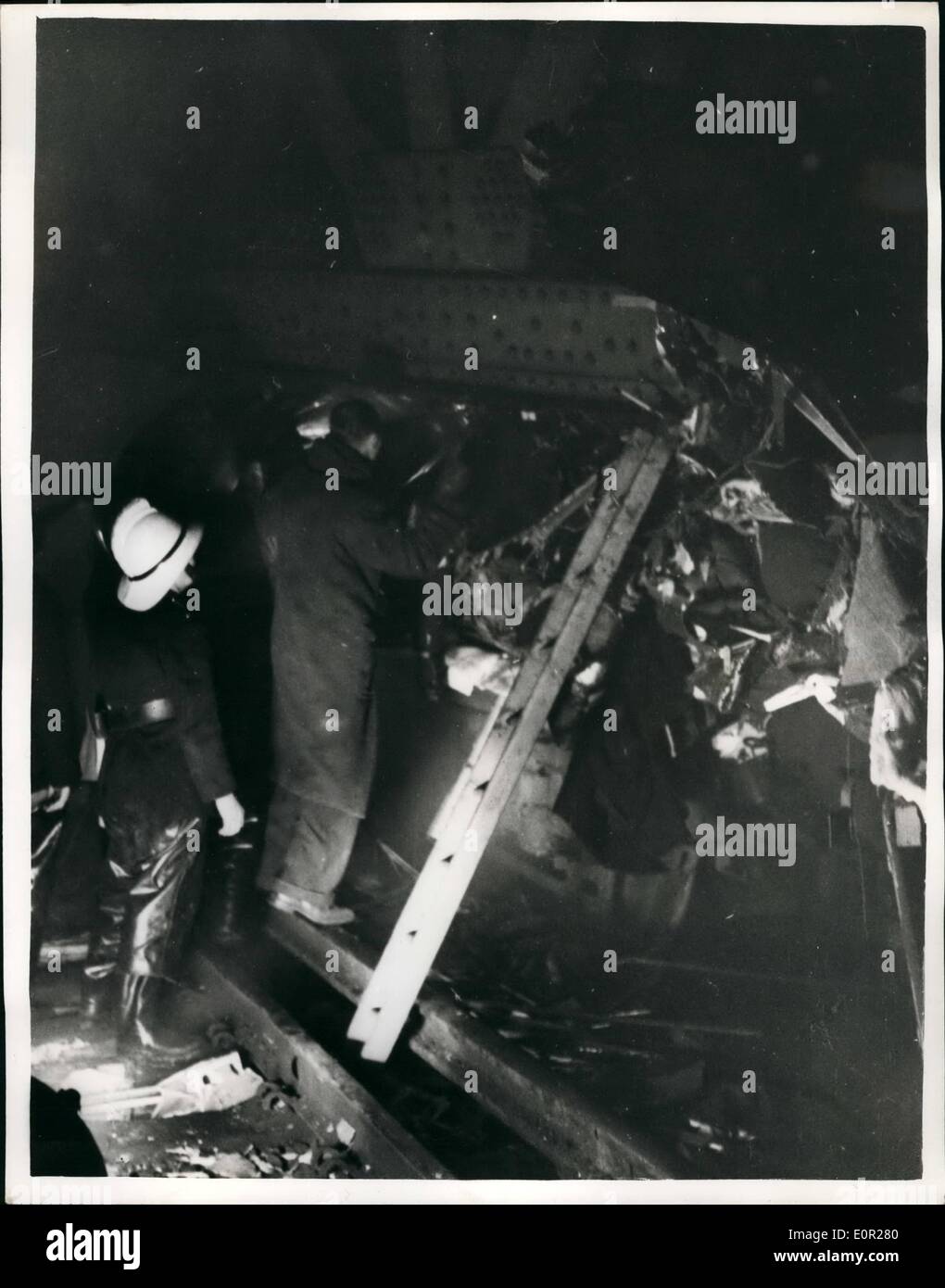 Dec. 12, 1957 - 64 Killed in Lweisham rail disaster; 64 people were killed and 200 injured in last night's rail disaster, when a steam train from Cannon-street to Ramasgate crashed into the stationary Charing Cross to Hayes electric train, just outside St. John's Station, Lewisham. Photo Shows Fireman fight through the tangled wreckage to reach a trapped made last night. Stock Photo