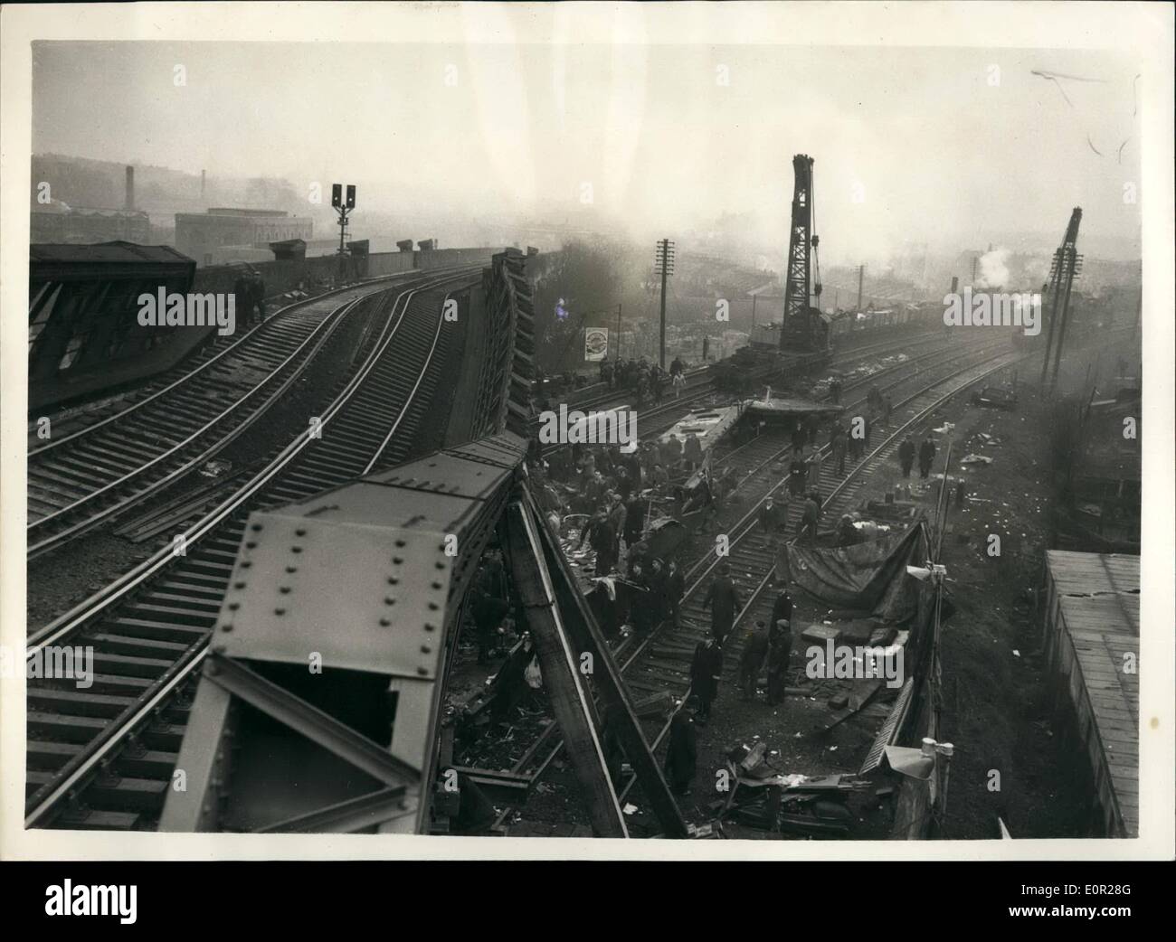 Dec. 12, 1957 - Rescue work goes on in the Lewisham Rail Disaster engineers try to raise the Fly over bridge: The death role has now reached 92 in Wednesday night's Lewisham rail disaster. Rescues have worked all night under are lights, and early this morning engineers were trying to raise the worked bridge to clear the coach on which the full weight of the fly over fall. Photo shows the first clear picture of the disaster taken after the fog had lifted today showing the collapsed fly over bridge with workmen below clearing the wreckage after the bridge had been partly shored up today. Stock Photo