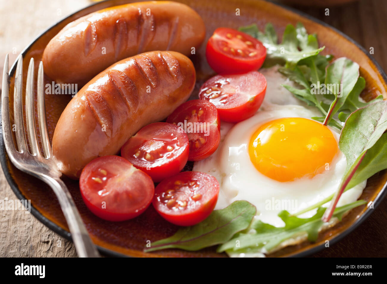 fried egg sausages tomatoes for healthy breakfast Stock Photo