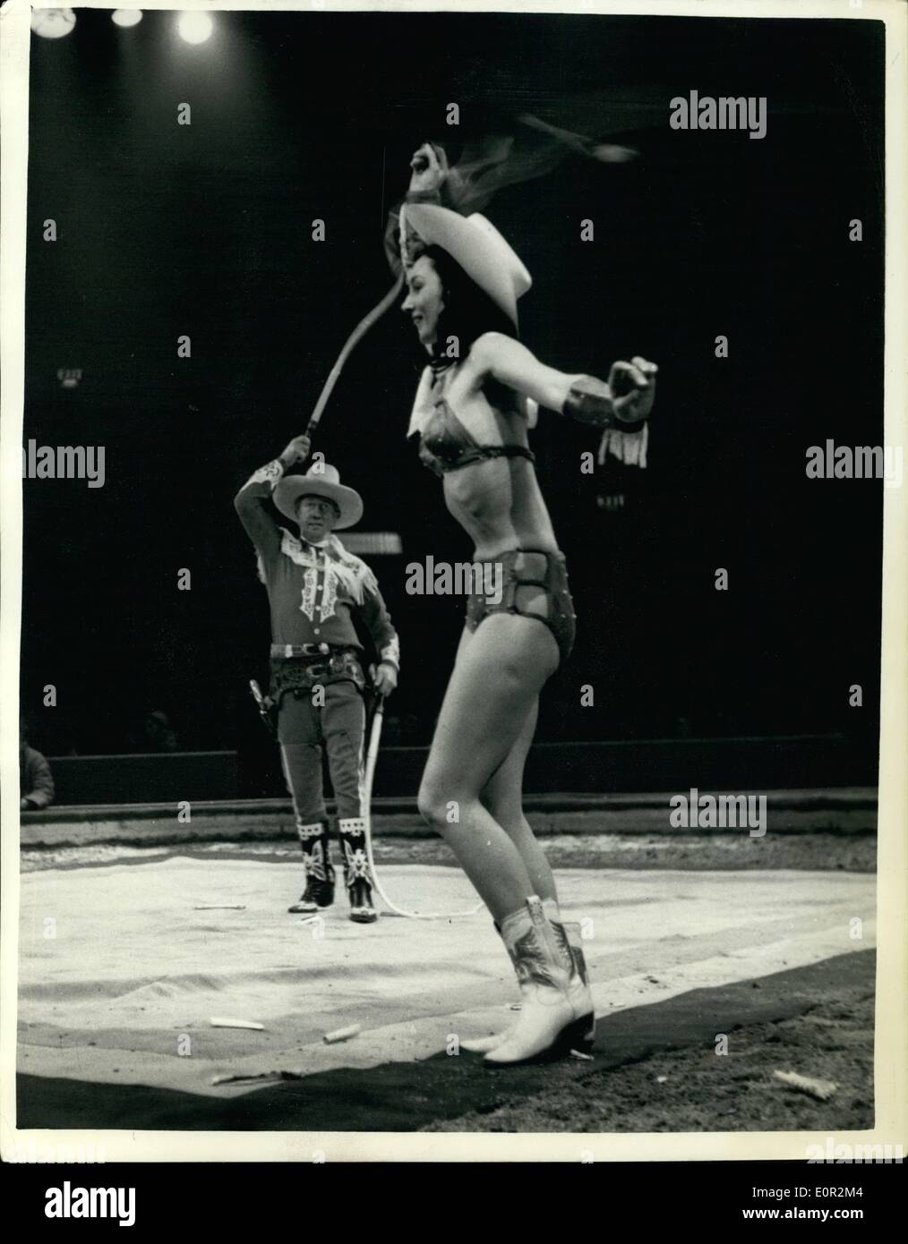 Dec. 12, 1957 - Olympia Circus Rehearsal. The ''Whip Cracking'' Act. Keystone Photo Shows: ''The Cordons'' - performing their whip cracking act - in which a match held by the girl is set alight by the whip - followed by the flicking away of a cigarette held in her lips... Seen during rehearsing at Olympia of the Bertram Mills Christmas Circus. Stock Photo