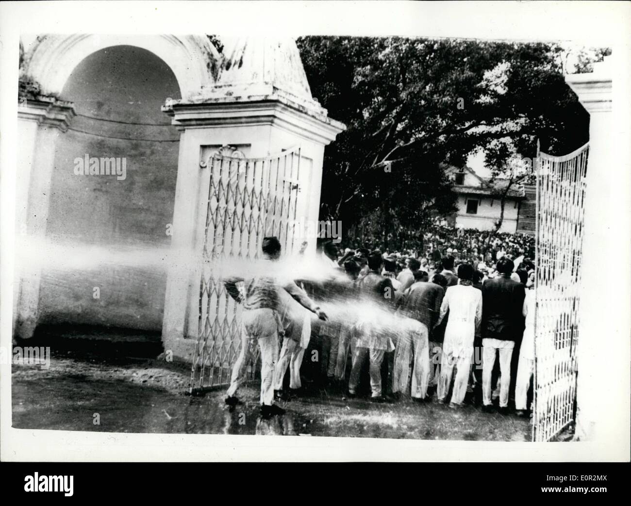 Dec. 12, 1957 - Civil Disobedience Movement in Nepal... Nepal's biggest political alliance of three progressive parties - launched a Civil Disobedience Movement - in a non violent form - in support of their demands for an early general election. Keystone Photo Shows: Members of the fire brigade hosing the pickets which formed outside the gate of the Secretariat... The pickets stood their ground. The police removed the pickets and released them from custody after about two hours. Stock Photo