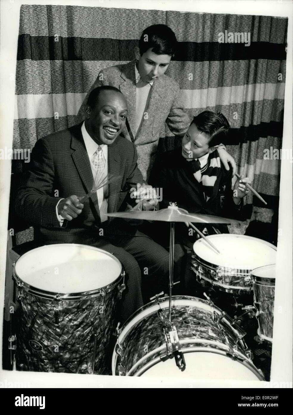 Oct. 19, 1957 - World Famous american Jazz player Teaches two London schoolboys to plays the drums. Lionel Hampton the famous American coloured Jazz- player has agreed to teach two London schoolboys Robin Brown (13) and his brother Jed (11) to day the drums. The boys are fans of Lionel Hampton - and are always playing his records. They hope to see him when he arrived in London - but his only performance was at a midnight charity matinee - and they could not attend . They telephoned him - and aske if they could she himplay - and he said ''I will do better than that - I will teach you Stock Photo