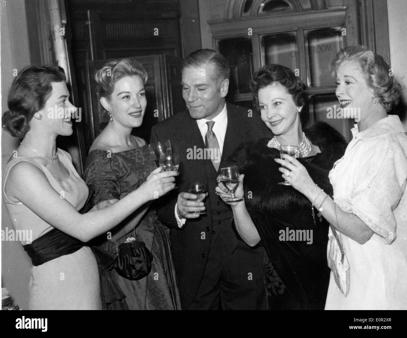 Actor Laurence Olivier toasting with co-stars of 'Summer of the Seventeenth Doll' Stock Photo