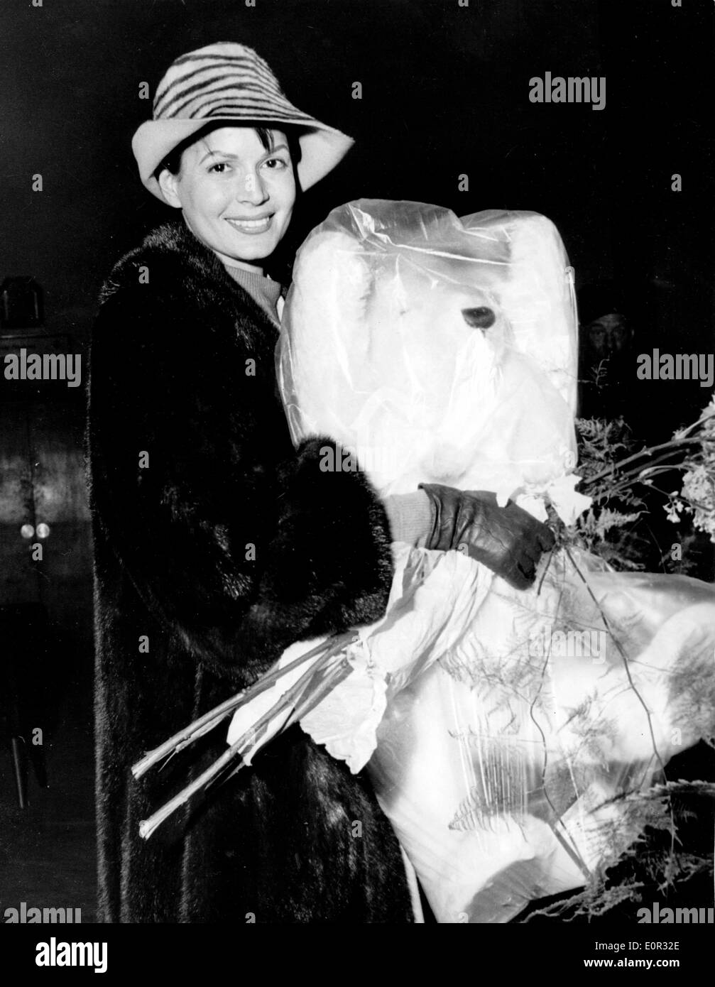 Actress Eva Bartok arriving at the airport carrying a huge teddy bear Stock Photo