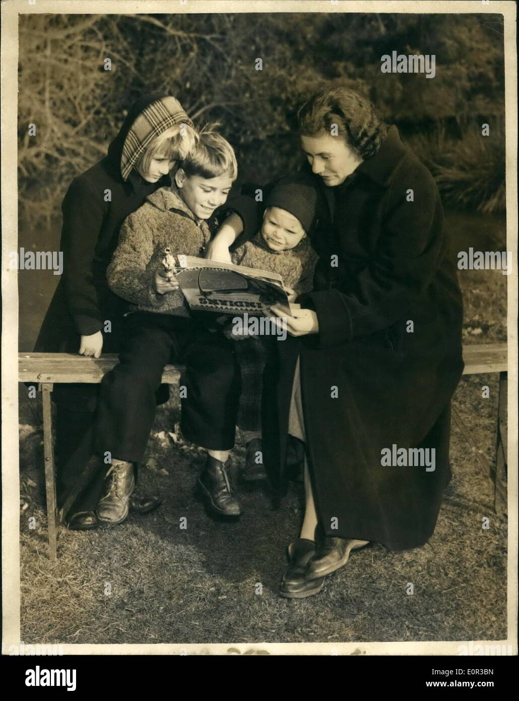 Jan. 01, 1958 - Hungarian refugee families that refused to be deported remain at camp. visited by : Members of the three Hungarian refuges families that on Saturday refused to be deported - were to be seen at Rowfant House, Cravlry this morning. The husbands, who are in Brixton Prison -were visited by their wives. Photo shows Mrs. Julie Farkus reads a fairy story to her three children in the grounds of Rowfant House, Crawley - this morning. Mrs. Farkus learned that she will be allowed to remain at the camp until her expected baby is born. Stock Photo