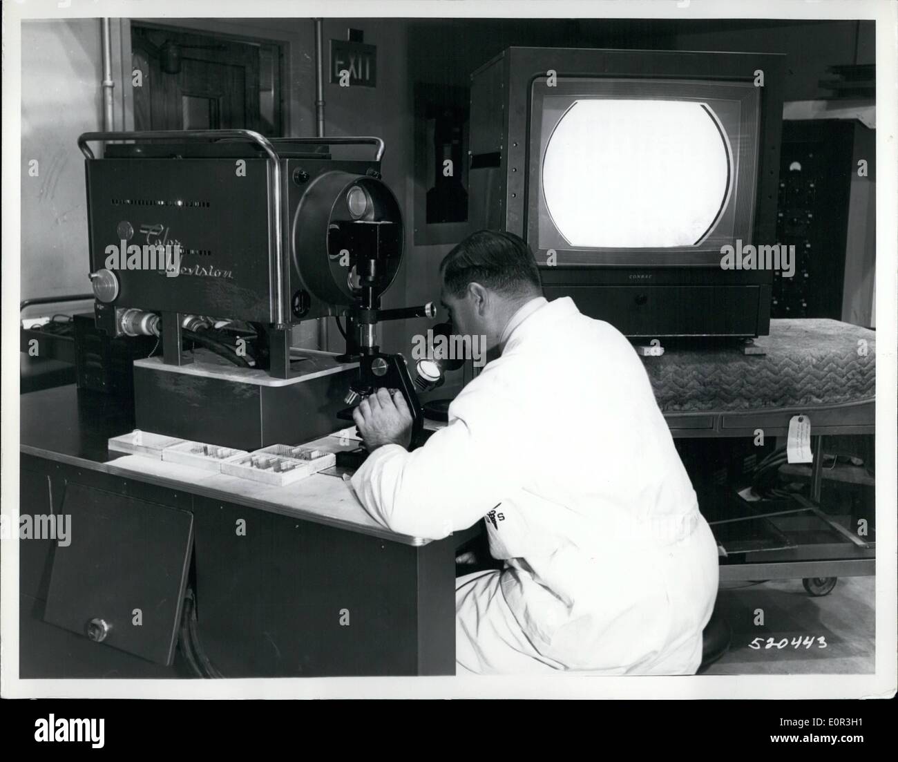 Nov. 11, 1957 - Army Medical Center's TV-Microscope; The US Army announced the development of a color TV microscope camera now in use at the Walter Reed Army Medical Center which enables the surgeon and the pathologist to examine together tissue removed from a patient during an operation. The tissue is sent from the operating room by pneumatic tube to the Pathology Laboratory, where a slide is prepared and inserted in the microscope. Audio connection permits discussion while surgeon and pathologist examine the specimen Stock Photo