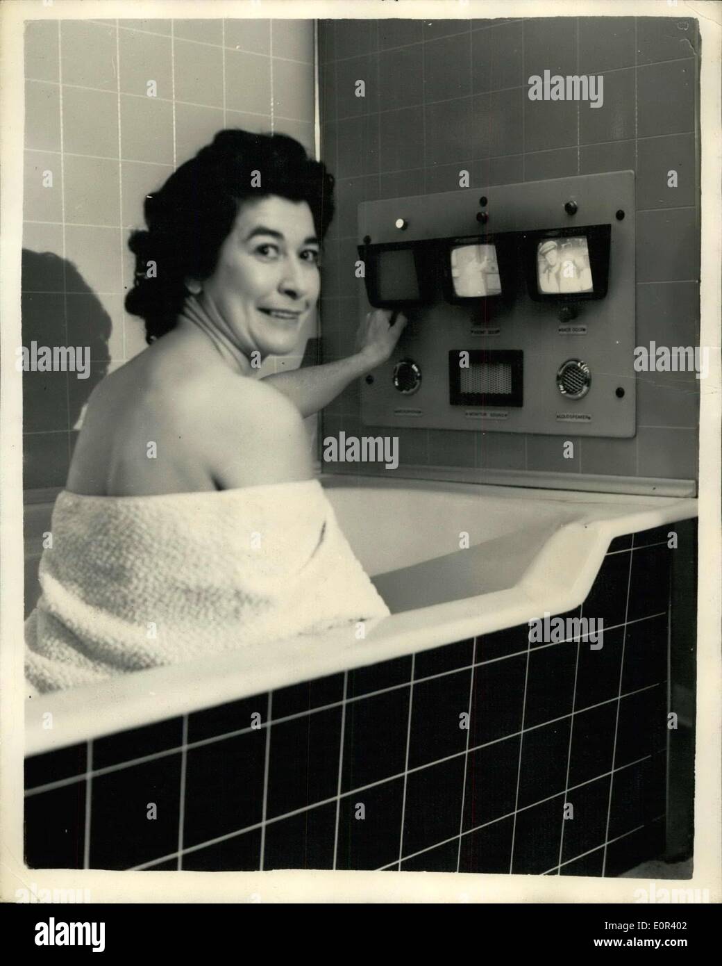 Nov. 13, 1957 - T.V. In The Bathroom - At Building Exhibition: Highlight of the London Building Exhibition which is being held at Olympia - is the demonstration of T.V. in the bathroom and is designed by Dennis Potts a plastic panel manufacturer. One screen enables the bather to keep on viewing while scrubbing the back - and the other two screens are coupled to the front and the back doors. If the housewife is in the bath she can just flick a switch - and up comes a picture of the caller with whom she can carry on a conversation. The system does not work in reverse Stock Photo