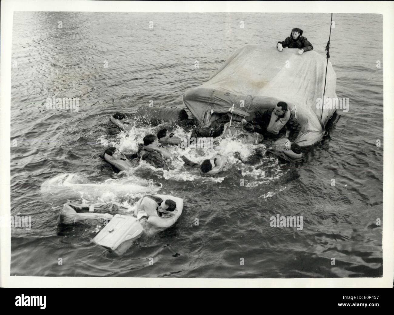 Jan. 20, 1958 - Testing Of Hydrostatic Release Units For Improved Inflatable Life Rafts.: The testing of hydrostatic release units for improved inflatable life rafts, took place today at Portsmouth Dockyard. Photo shows Abandon Ship! - Naval airmen wearing standard exposure suits - abandon life-raft as it goes down from one and, after one of the naval airmen had accidentally punctured the raft with a knife, during the testing today. Stock Photo