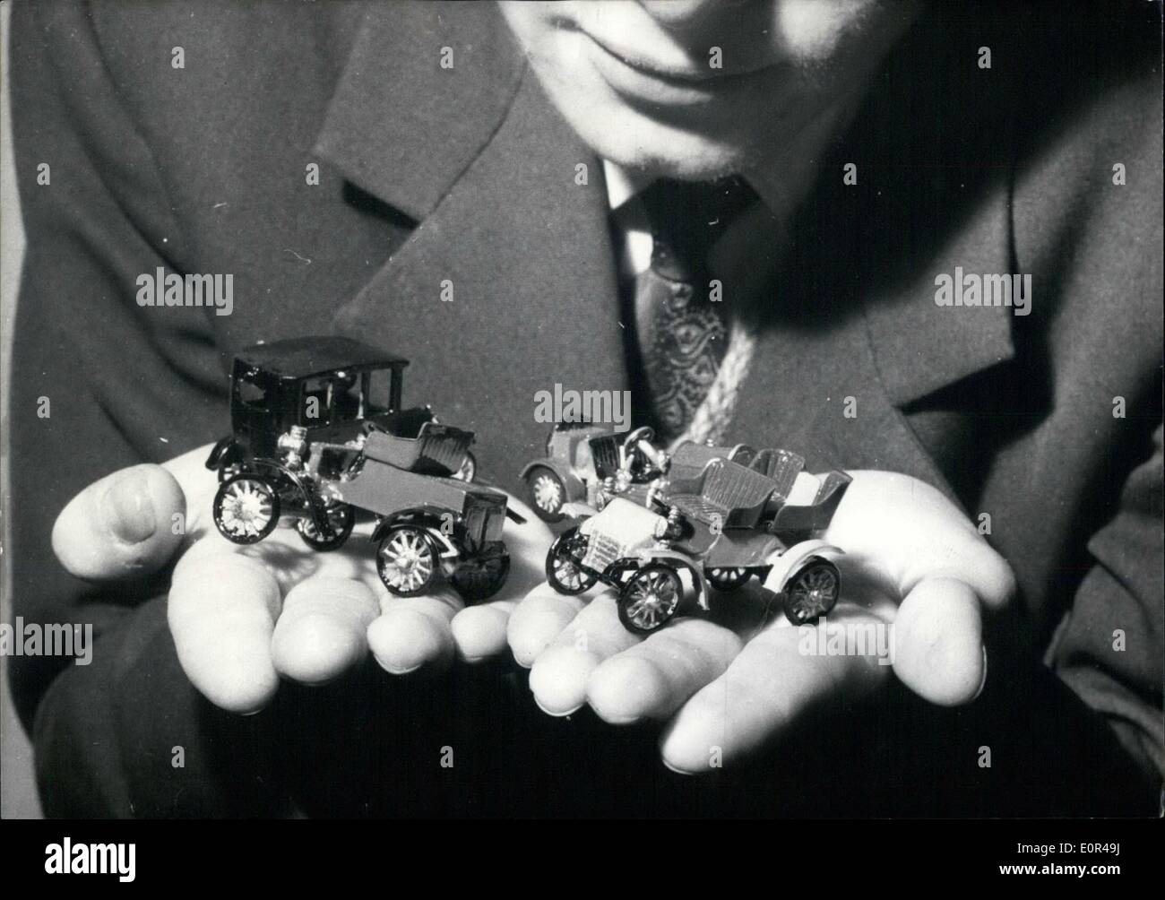 Dec. 12, 1957 - A miniature motor show opened in a champs-Elysees exhibition hall yesterday. Photo shows a young visitor holding in the palm of his hands diminutive models of some Prehistoric cars. Stock Photo